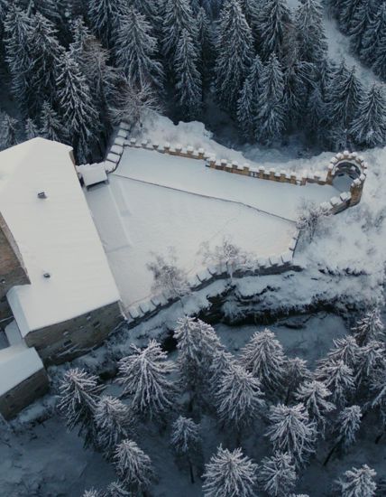 Das schneebedeckte Schloss Welsperg von oben