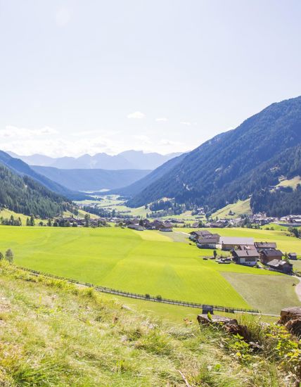 Panoramic view over the green Gsies Valley and the surrounding mountains.
