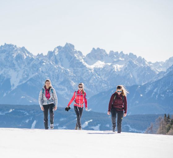 Tre donne che fanno un'escursione invernale nelle Dolomiti